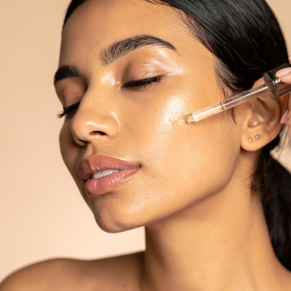 close-up on person's face, applying clear facial product to cheek with dropper, eyes closed, relaxed